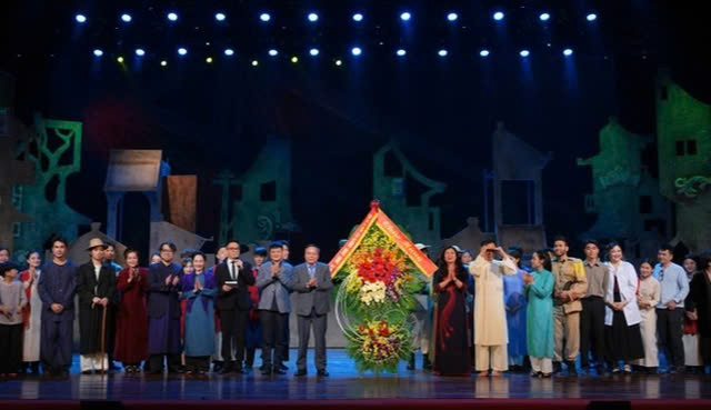 Ông Nguyễn Văn Phong - Phó Bí thư Thường trực Thành ủy Hà Nội tặng hoa chúc mừng các nghệ sĩ. Ảnh: Báo Tổ Quốc