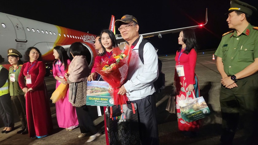 Đại diện Trung tâm Xúc tiến Du lịch tặng hoa, quà lưu niệm Quảng Bình cho du khách. Ảnh: Báo PLVN